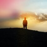 silhouette of person standing on hill