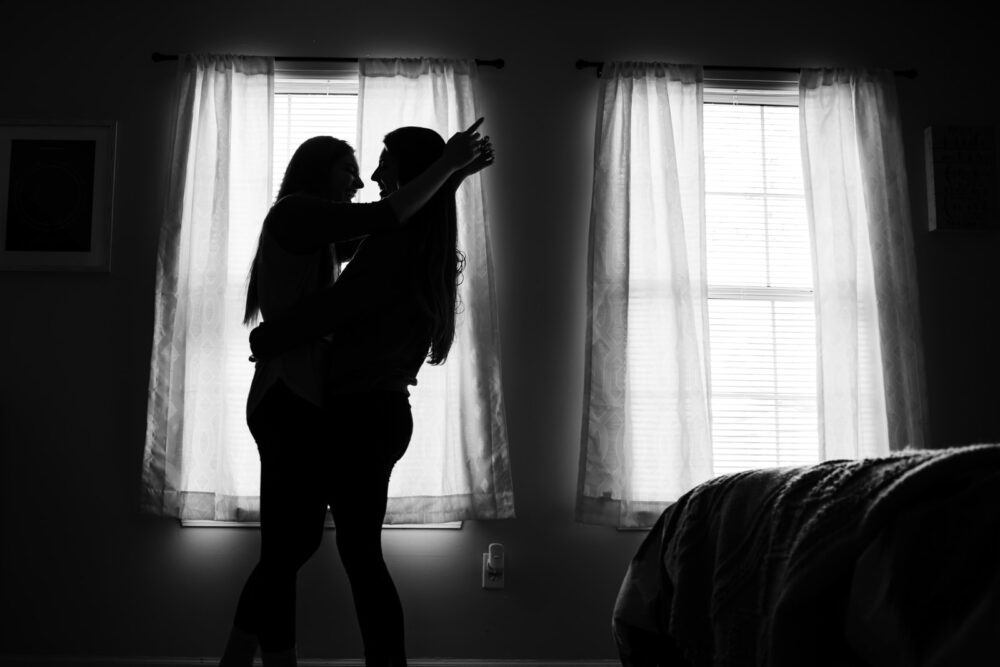 silhouette of two person standing inside dark room
